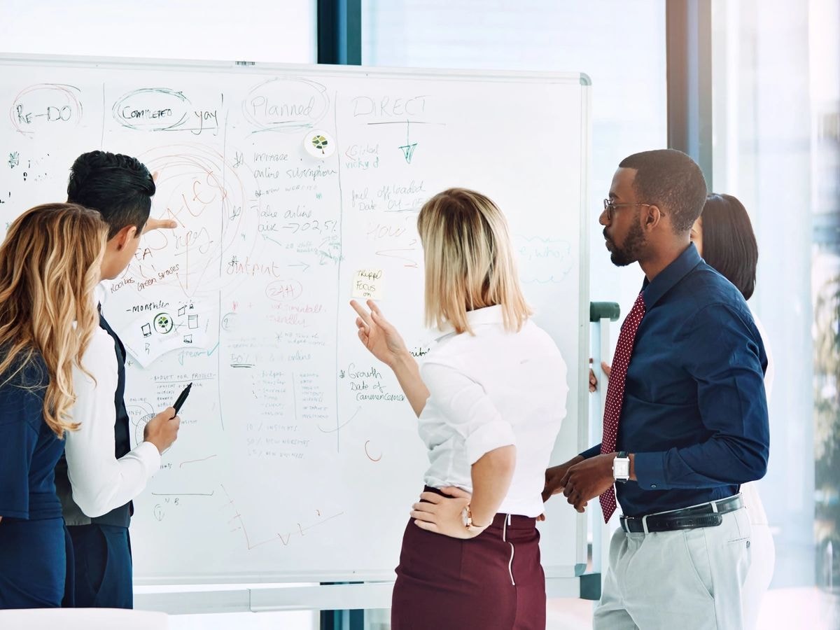 Diverse team in a strategy session with whiteboard